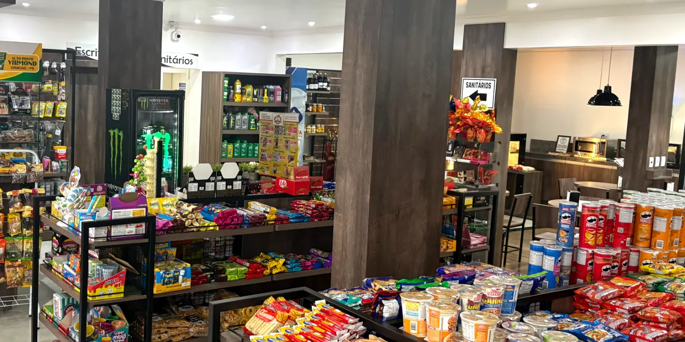 Interior da conveniência do Auto Posto Virmond, com gôndolas de snacks, doces e bebidas